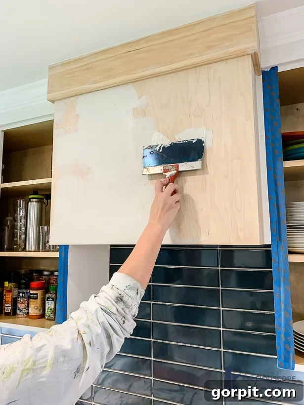 DIY Wood and White Concrete Range Hood 8 applying white skimcoat concrete to range hood surface