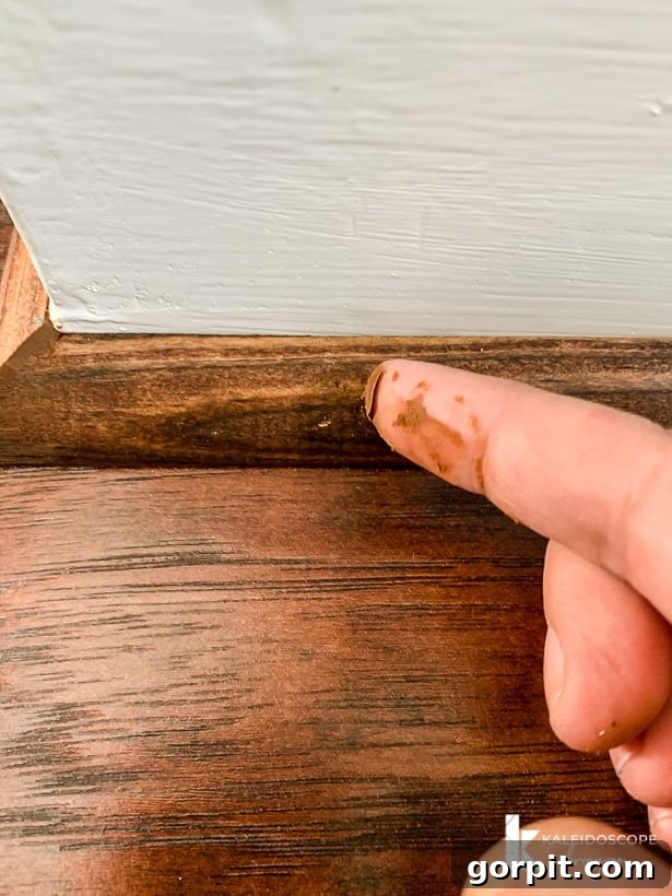 Your Guide to Perfect Quarter-Round Molding 11 A finger spreads Mohawk Patchal Putty over nail holes in quarter round molding, ensuring a smooth and invisible finish.