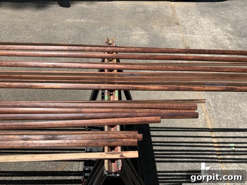 Your Guide to Perfect Quarter-Round Molding 3 A sawhorse outside holds lines of stained quarter round molding trim, ready for installation.