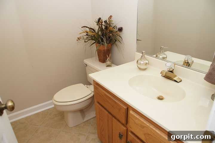 Outdated powder room with beige walls and basic fixtures before renovation.