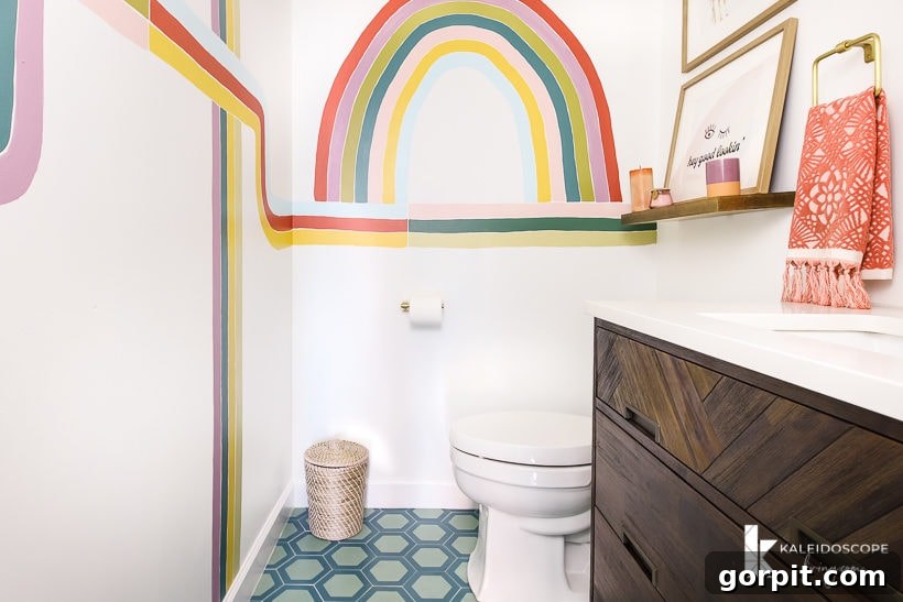 Colorful powder room with geometric cement tile flooring and a vibrant wall mural, reflecting modern style.