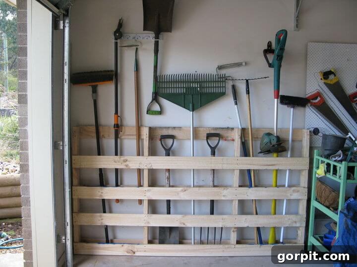 DIY pallet tool organizer in garage for shovels, rakes and yard tools