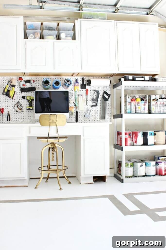 organized garage with cabinetry and painted greek key floor