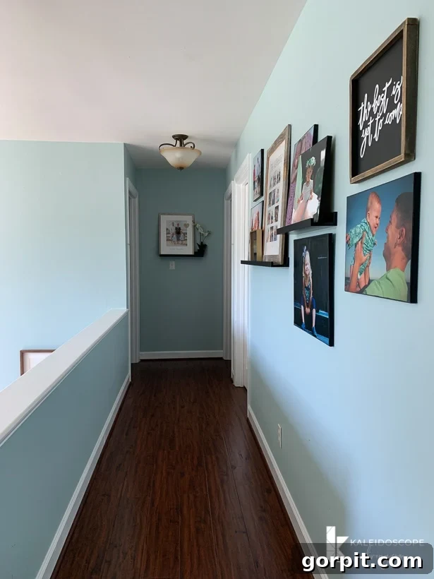 Upstairs Hallway's Colorful Glow-Up 2 Outdated upstairs hallway with family photos and old ceiling lights before makeover