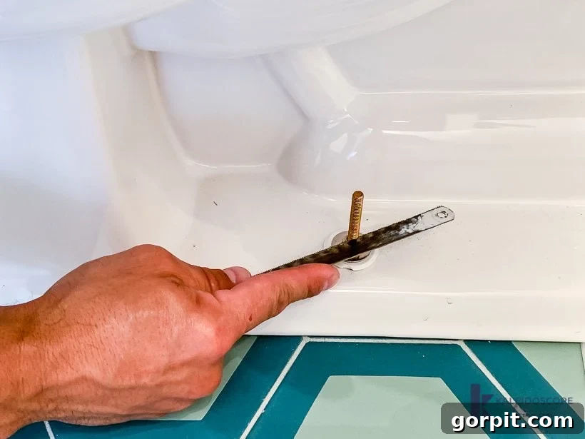 Trimming excess toilet bolts with a hacksaw for aesthetic finish