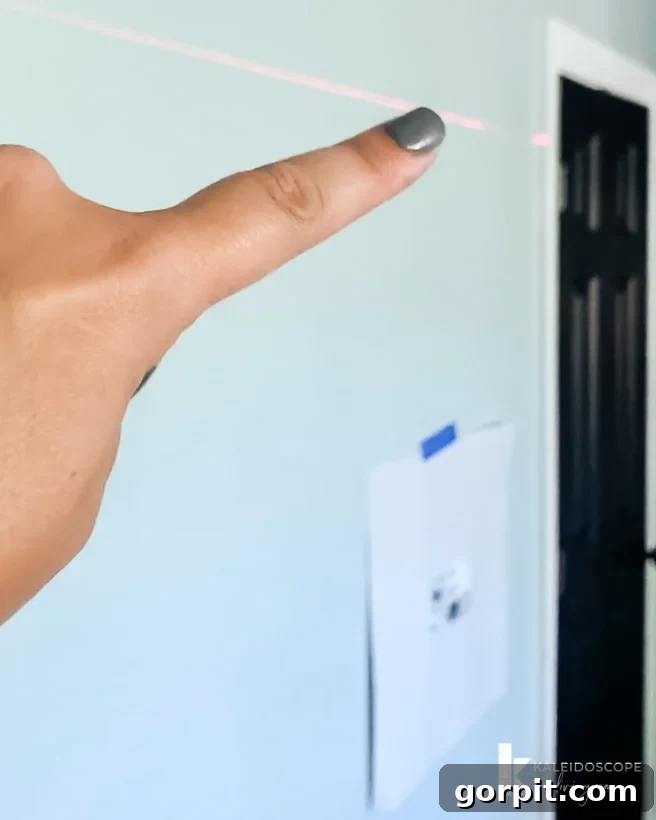 Ensuring alignment of photo gallery wall frames with a laser level for a professional finish