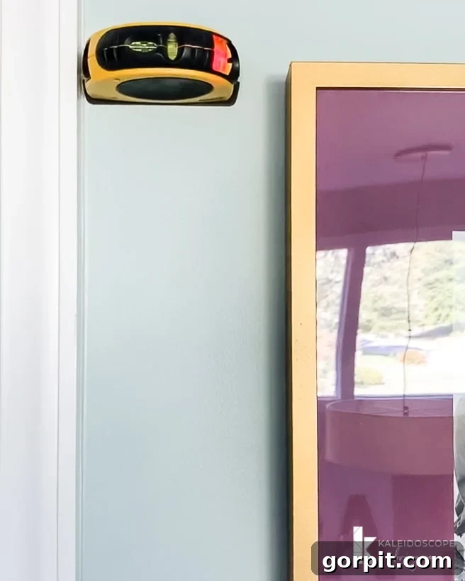 Using a laser level to ensure perfectly straight frames on a photo gallery wall
