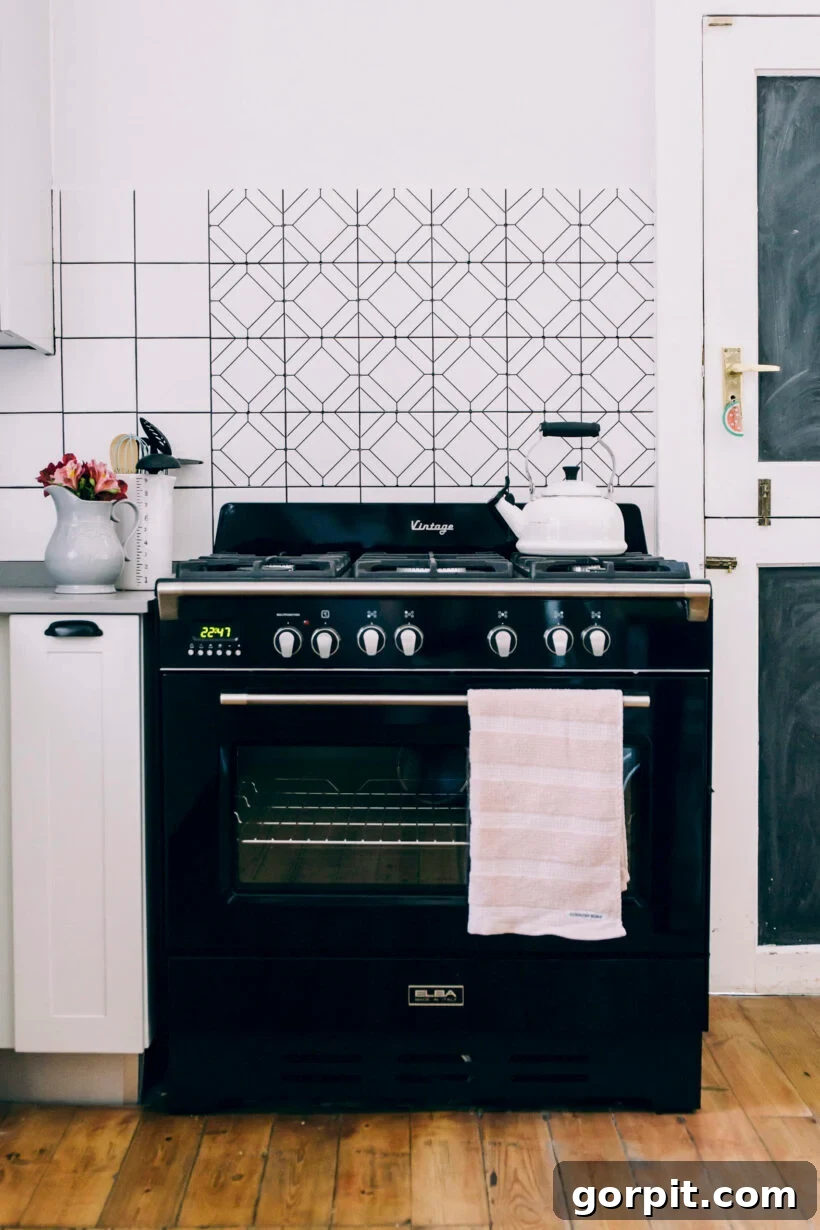 Cricut vinyl designs make a simple, renter-friendly backsplash in this black and white kitchen. 