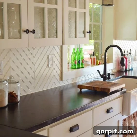 White chevron beadboard looks fresh and modern as a budget-friendly backsplash in this black and white kitchen. 