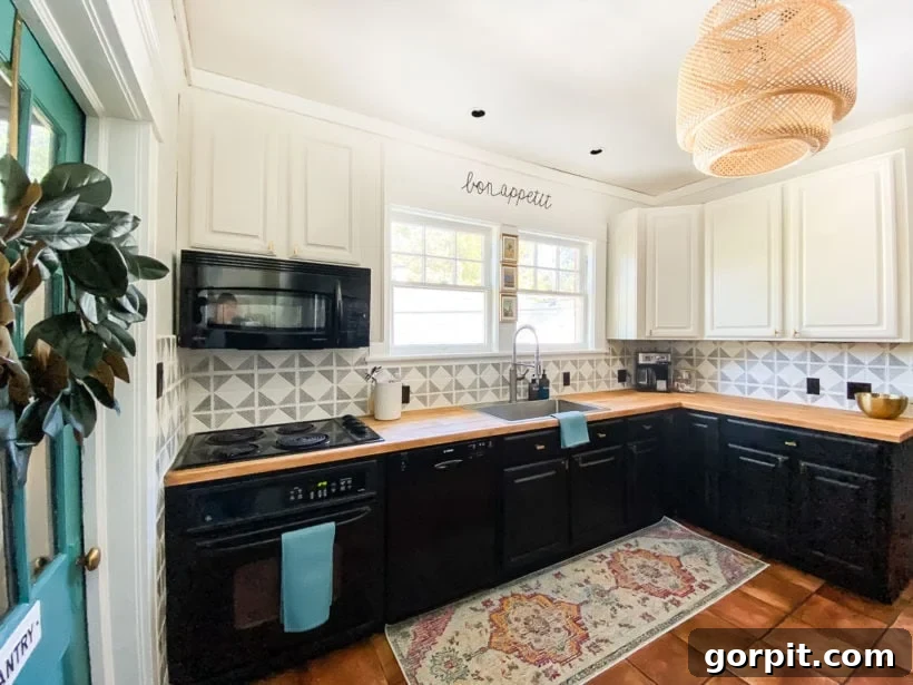 Small Budget Big Impact DIY Kitchen Transformation 2 A budget-friendly kitchen makeover "after" picture shows an L-shaped wood counter with glossy black lower cabinets and white upper cabinets.