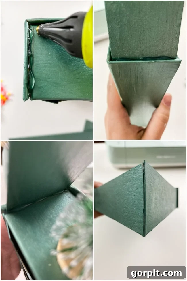 Assembling the painted chipboard rooftop onto the Advent calendar base using a hot glue gun to create a charming house structure.