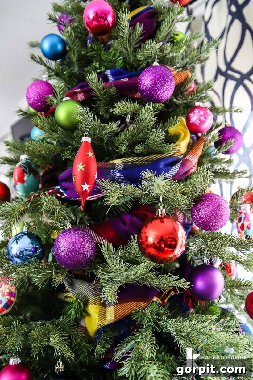 Vivacious Holiday Tree 3 A vibrant Christmas tree featuring a unique colorful scarf garland, artfully draped amidst sparkling ornaments, creating a soft and textured appeal