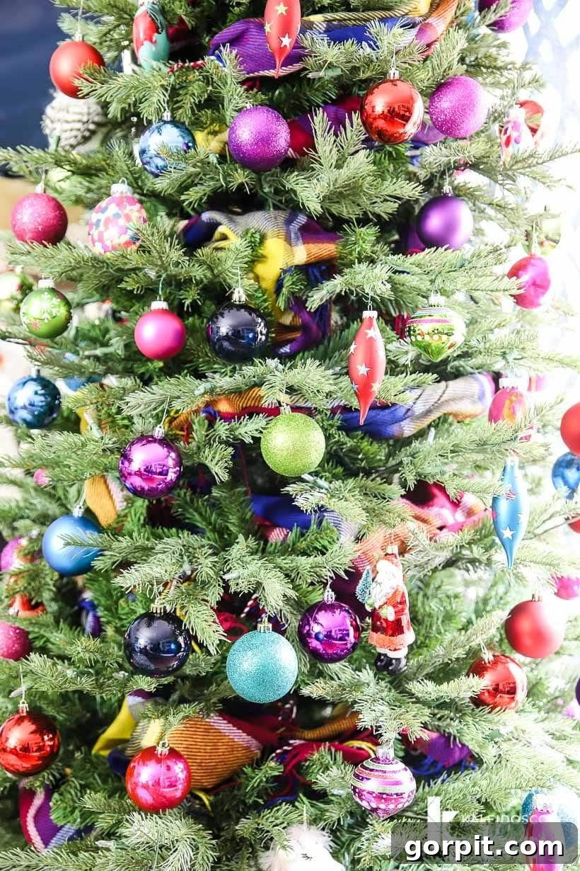 Vivacious Holiday Tree 4 Close-up of a brightly decorated Christmas tree, showcasing a rich variety of colorful ornaments with different textures and finishes, nestled within the green branches and highlighted by a unique scarf garland