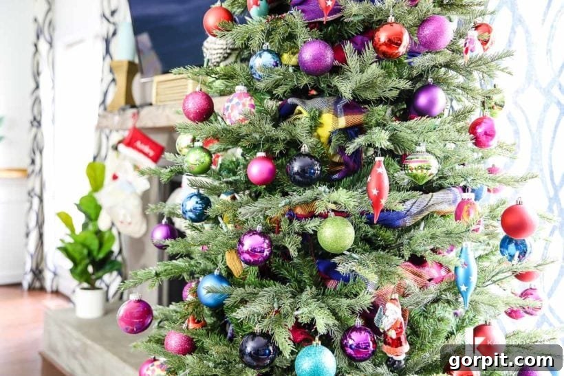 Vivacious Holiday Tree 5 A beautifully decorated bold and bright Christmas tree in a modern family living space, adorned with an abundance of colorful ornaments and a unique scarf garland, creating a joyful ambiance