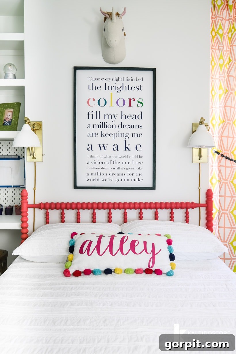 Colorful girl's bedroom with a coral-painted Jenny Lind bed and custom lyrical art above it.