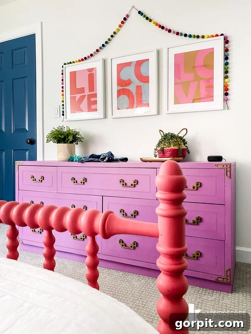 Detailed view of the colorful girl's bedroom with a restored purple dresser and whimsical wall accents.