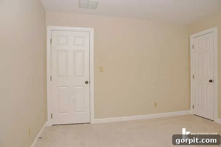 Plain, empty bedroom before makeover, showcasing a bare window and neutral tones.