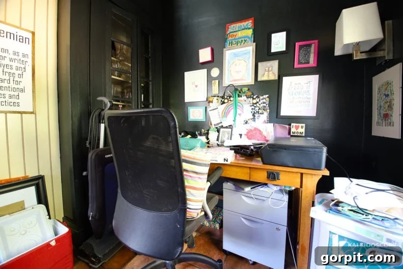 Outdated dark home office with hidden built-in cabinet