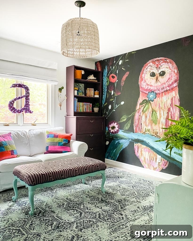 A DIY macrame ceiling lampshade hangs in a young girl's bedroom by a wall mural of an owl, a white couch, and a felt-ball letter 