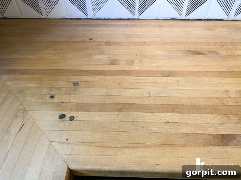 A "before" photo of damaged, stained and scratched butcher block countertops in kitchen.