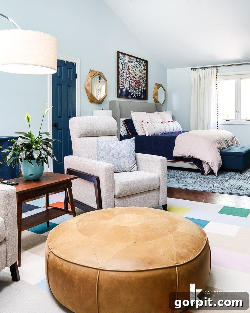 The sleeping area of the colorful master bedroom with a large rug and sitting area visible