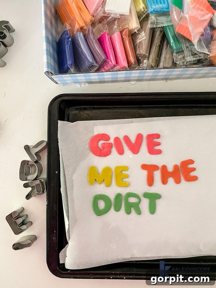 Hand smoothing polymer clay shapes with water on parchment paper before baking