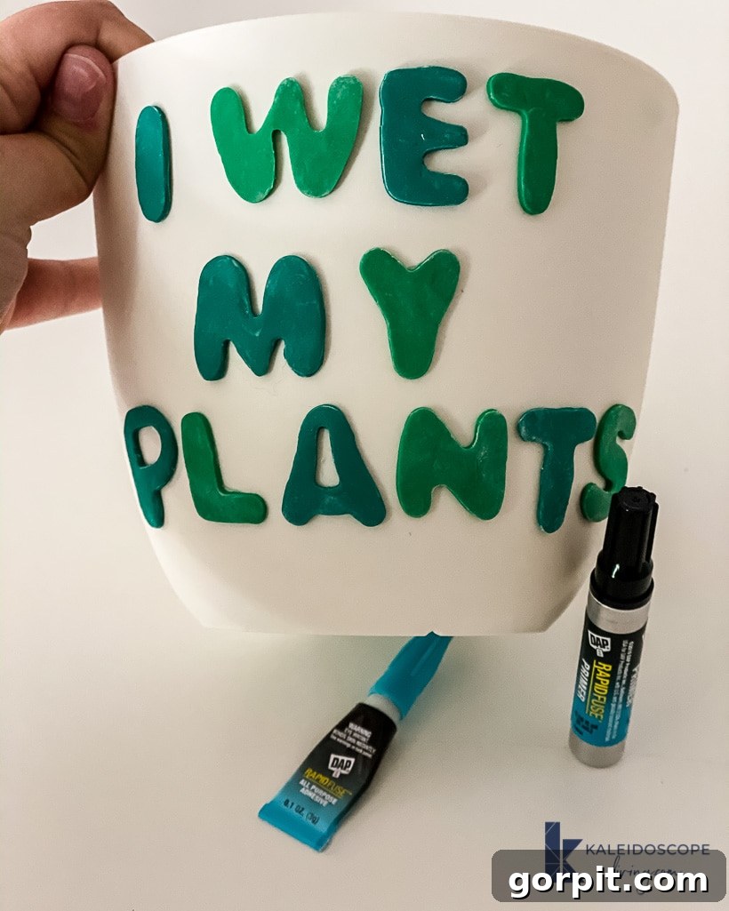 Adhering a polymer clay shape onto a plastic plant pot with DAP Rapid Fuse