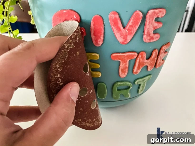 Close-up of a decorated plant pot showing sanded and waxed polymer clay details