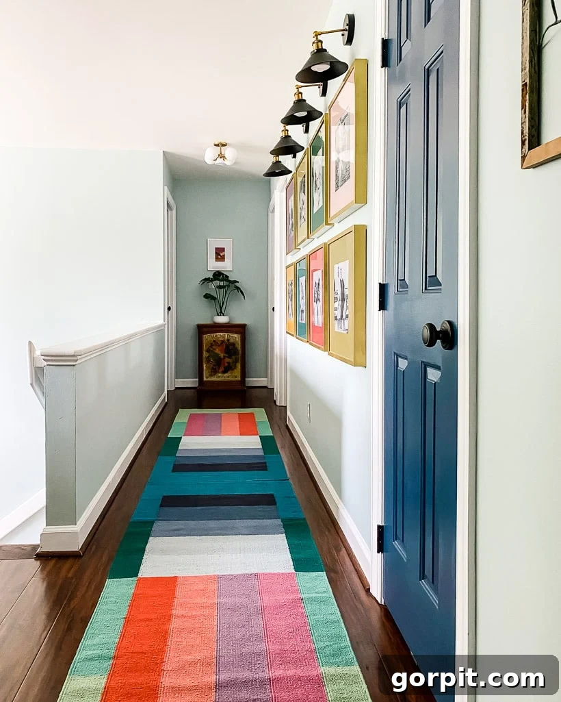 A Burst of Summer: My Colorful Home Unveiled 4 Close-up of a colorful runner in an upstairs hallway, complementing a vibrant gallery wall with decorative sconces.