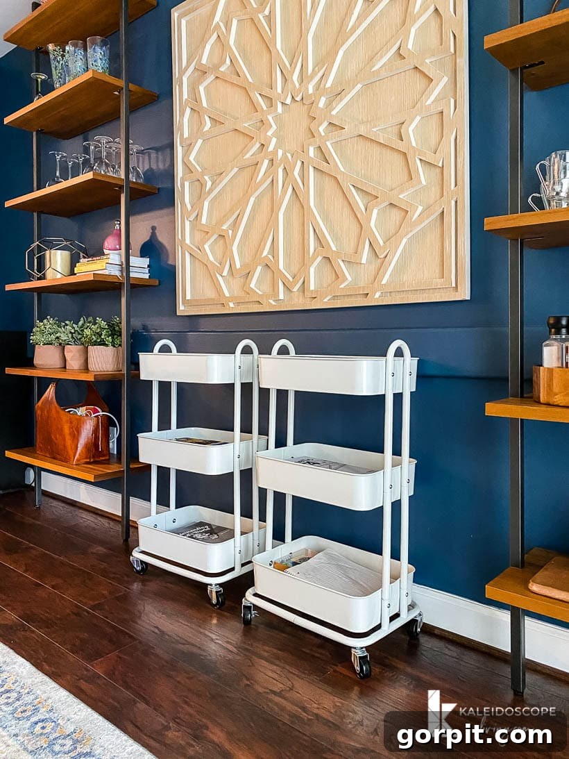 Streamline Your Homeschool: Genius Organization Strategies 3 Homeschooling organization in dining room with carts against a blue wall between tall shelves, illustrating a practical learning setup.