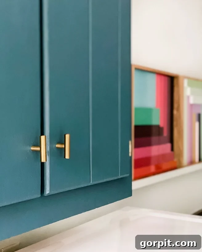 teal painted cabinets with brass hardware