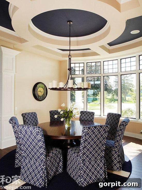 Dining room featuring a bold navy blue wall contrasted with crisp white walls and elegant ivory trim, creating a rich and sophisticated ambiance.