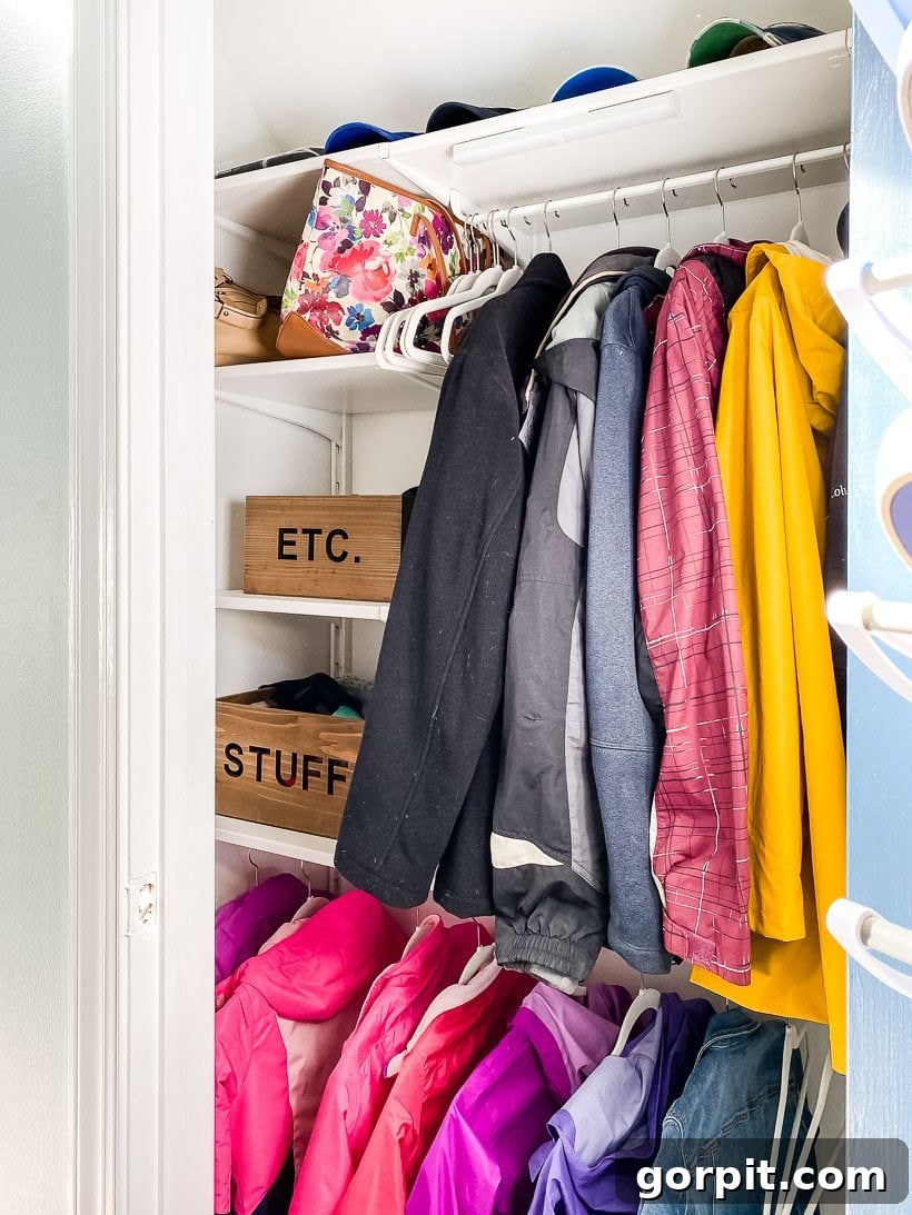 Beautifully organized coat closet with coats, shoes, and accessories neatly arranged