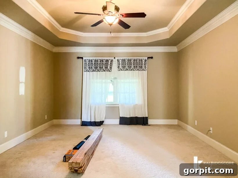 Our New House: The Starting Point Tour Part 1 13 Master bedroom featuring a tray ceiling, large windows, and initial stages of hardwood floor installation.
