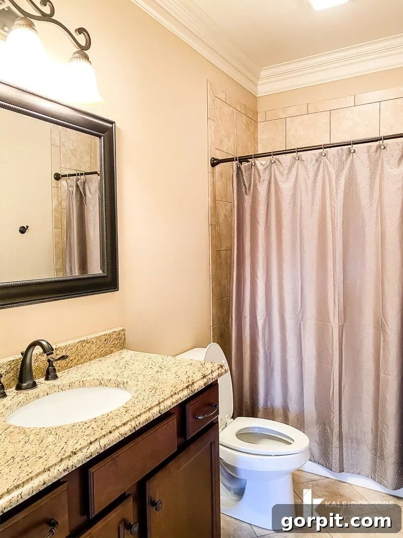 Attley's bathroom before renovation, with brown cabinets and tile.