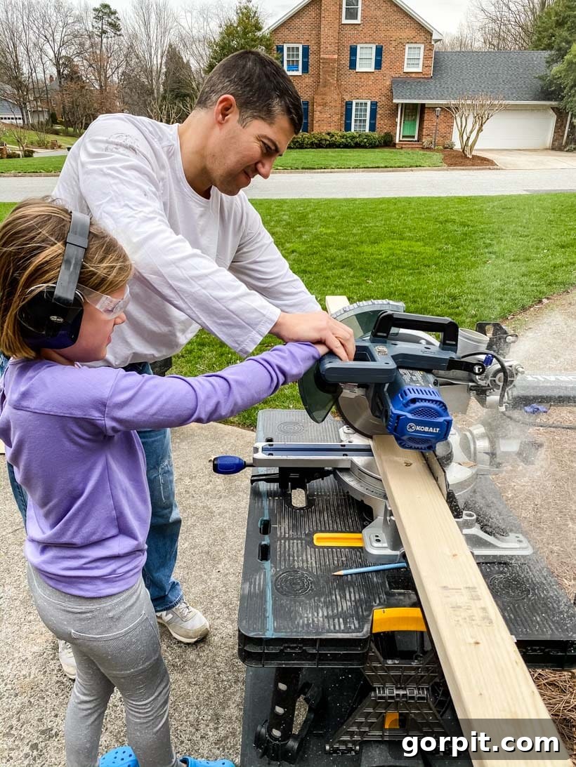 father and daughter using saw together