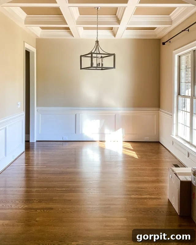Welcome to Our Navy Dining Room 2 A "before" of a beige dining room with coffered ceiling and white wainscotting before it is transformed into a navy-blue dining room.