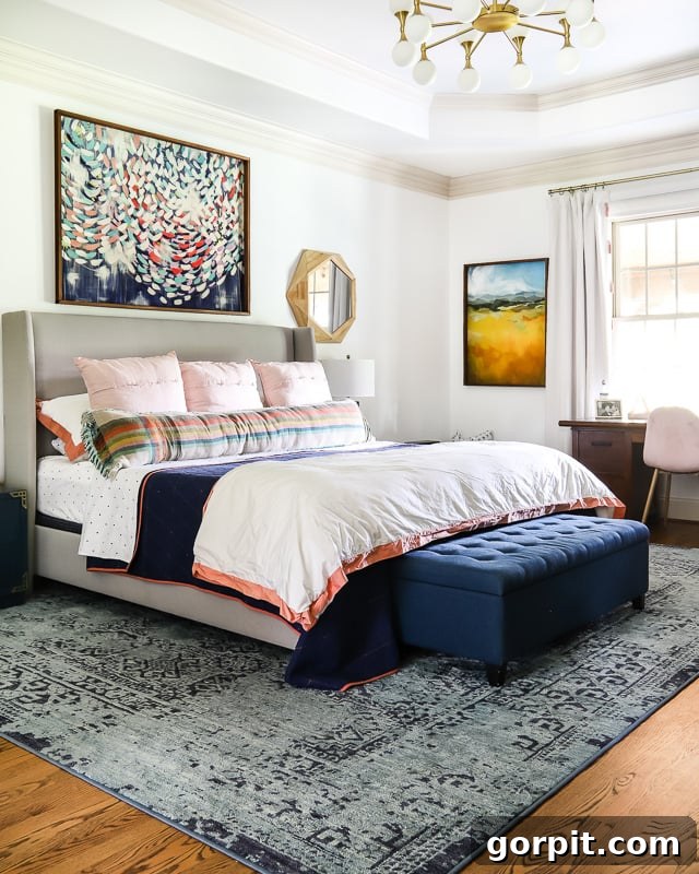The Art of Grand Scale Elevate Your Home with Oversized Decor and Sourcing Secrets 5 A colorful bedroom featuring a large abstract art piece above the bed and stylish navy bedding.