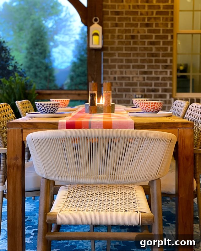 A detailed view of the screened-in porch at night, showing the interplay of light and shadow on the comfortable furniture.