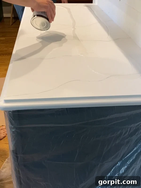 pouring epoxy resin topcoat on painted kitchen countertops by Tasha Agruso of Kaleidoscope Living