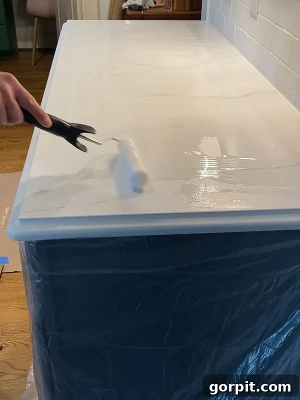 spreading epoxy resin topcoat on painted kitchen countertops by Tasha Agruso of Kaleidoscope Living