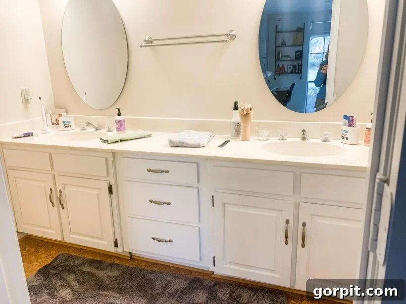 Before: Boring builder-grade bathroom with a neutral palette and basic finishes, lacking character and vibrancy.