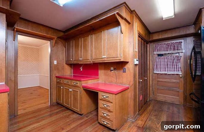 Before: Kitchen with a large shelf over cabinets and an uneven countertop, creating a closed-off and dated feel.