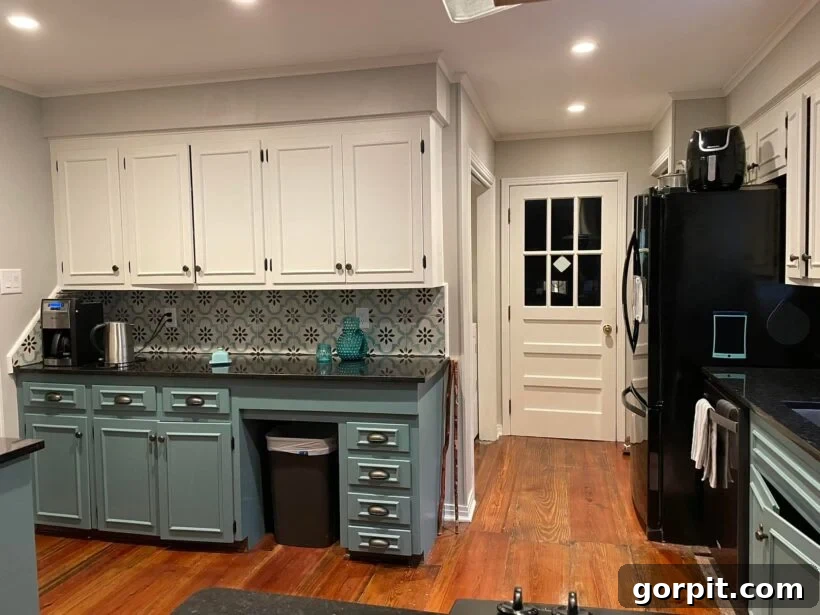 After: Bright and open kitchen with upper shelf removed, leveled countertops, painted cabinets, and modern finishes, creating a completely transformed space.
