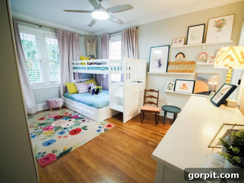 After: Colorful and whimsical kids' room featuring bunk beds, a Rifle Paper Co. rug, and abundant pink accents, creating a playful and personalized space.