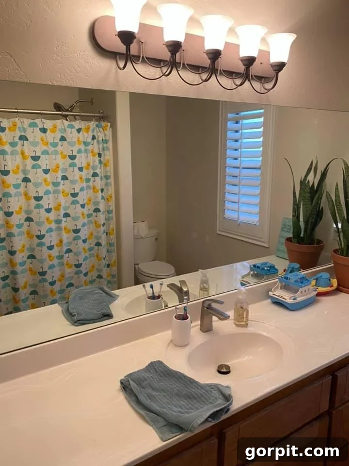 Before: Outdated bathroom with dark wood cabinets and a simple mirror, lacking modern appeal.