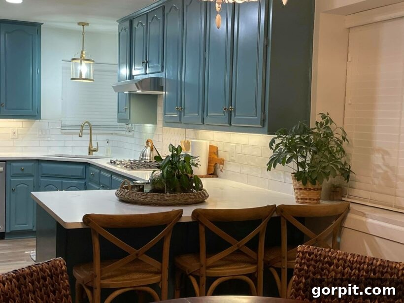 After: Bright and modern kitchen featuring painted white cabinets, new hardware, and fresh decor, completely revitalized.
