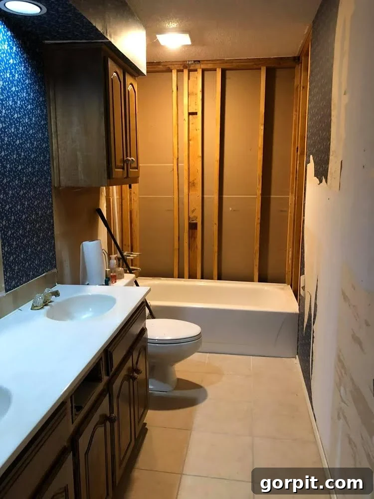 Before: Old bathroom undergoing renovation, showing a basic and dated appearance before the update.
