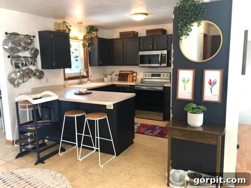After: Remodeled kitchen with freshly painted light cabinets, new light fixtures, and updated surfaces, creating a bright and modern space on a budget.