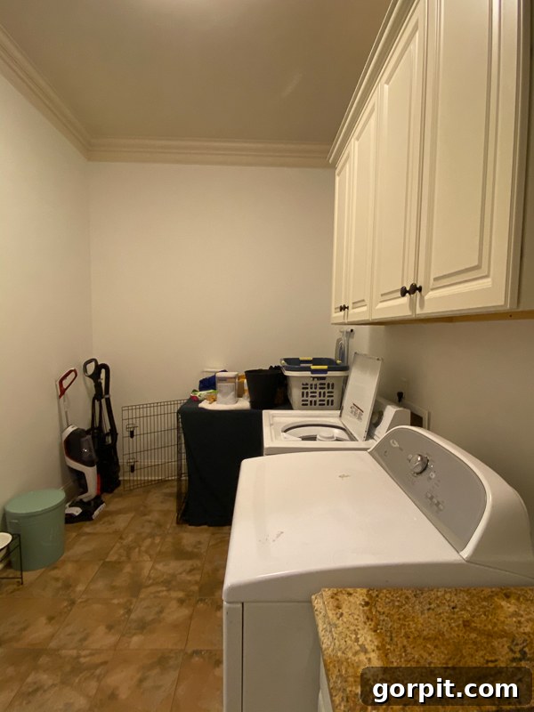 outdated laundry room before makeover - cluttered upper cabinets